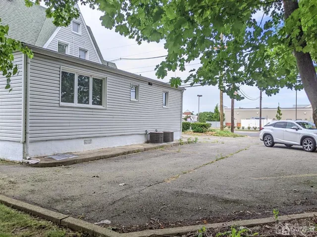 a view of a white house next to a yard