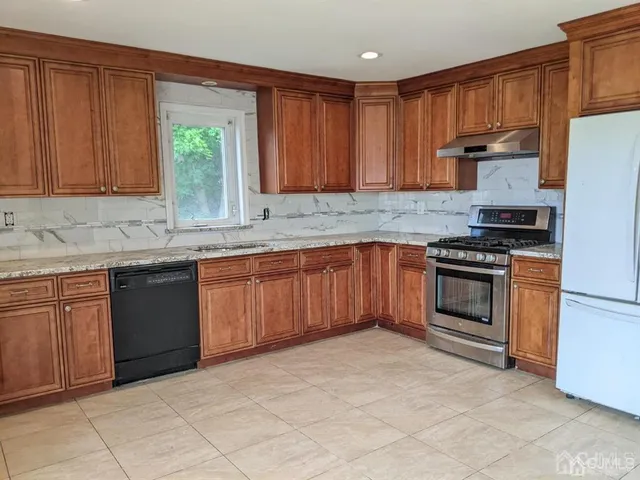 a kitchen with granite countertop a stove sink and cabinets