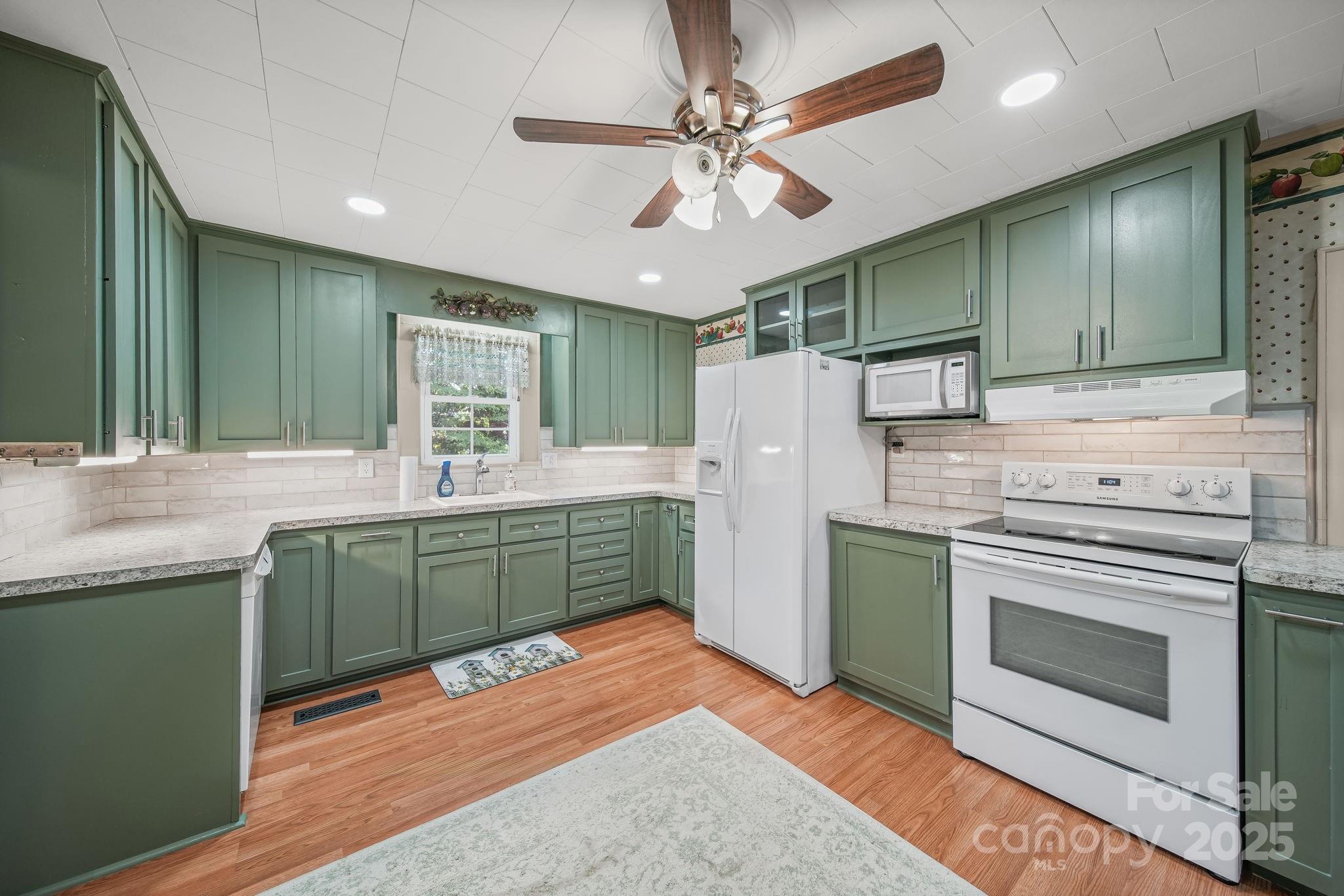 210 Smith Street Clover, SC 29710 - Photo 13 of 33 a kitchen with kitchen island a sink stainless steel appliances and cabinets