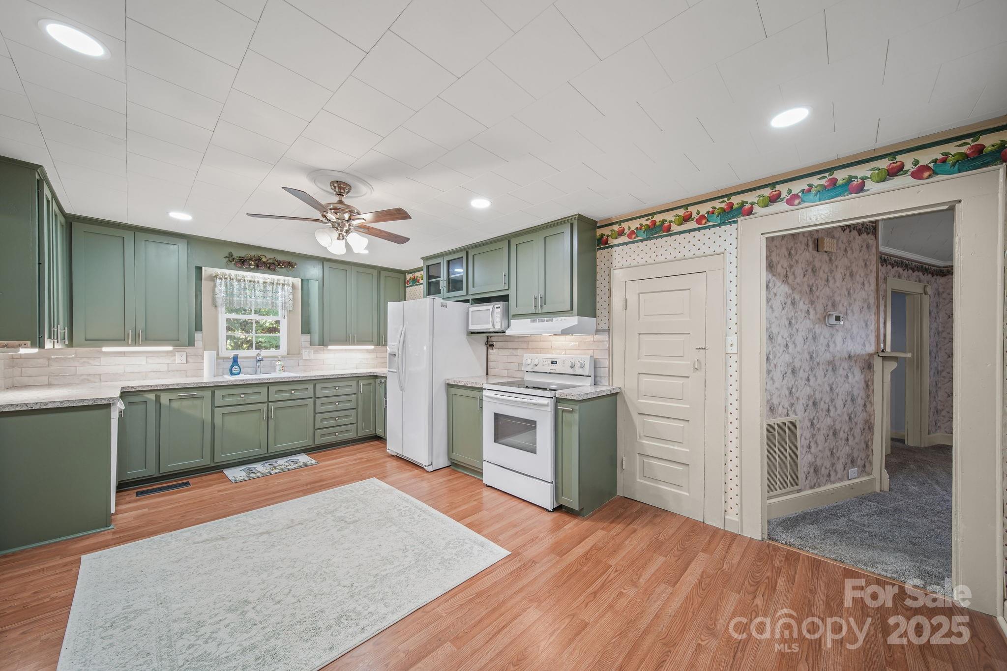 210 Smith Street Clover, SC 29710 - Photo 14 of 33 a kitchen with cabinets and wooden floor