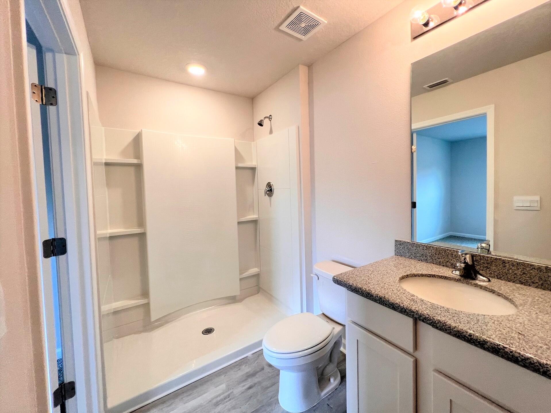 334 Flounder Street Crestview, FL 32539 - Photo 11 of 24 a bathroom with a granite countertop sink a toilet and shower