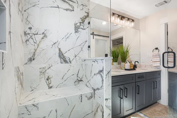 a bathroom with a granite countertop sink and a mirror