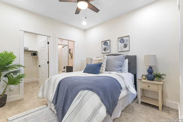 a spacious bedroom with a bed and a potted plant
