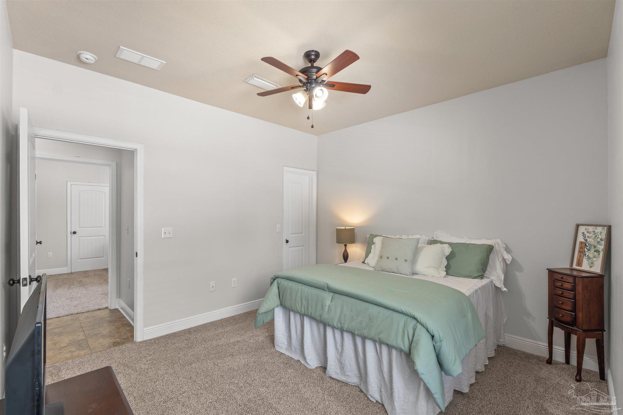 2698 Tulip Hill Road Pace, FL 32571 - Photo 36 of 65 a bedroom with a bed and a chandelier