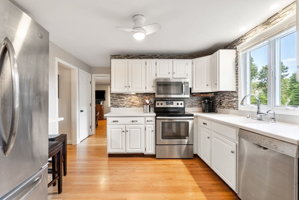 11 Sycamore Road Scituate, MA 02066 - Photo 14 of 39 a kitchen with stainless steel appliances white cabinets a sink a stove a refrigerator and cabinets