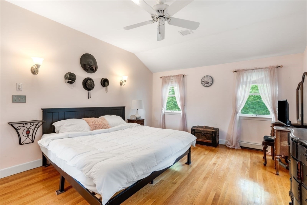 11 Sycamore Road Scituate, MA 02066 - Photo 26 of 39 a bedroom with a bed and a table in it with wooden floor