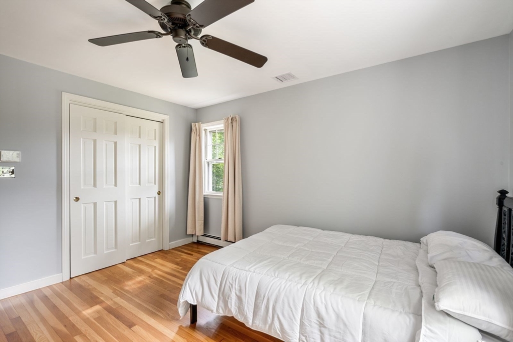11 Sycamore Road Scituate, MA 02066 - Photo 30 of 39 a bedroom with a bed and a chandelier