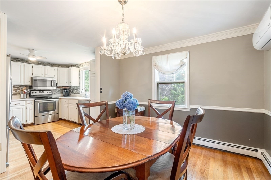 11 Sycamore Road Scituate, MA 02066 - Photo 9 of 39 a view of a dining room with furniture a chandelier and wooden floor