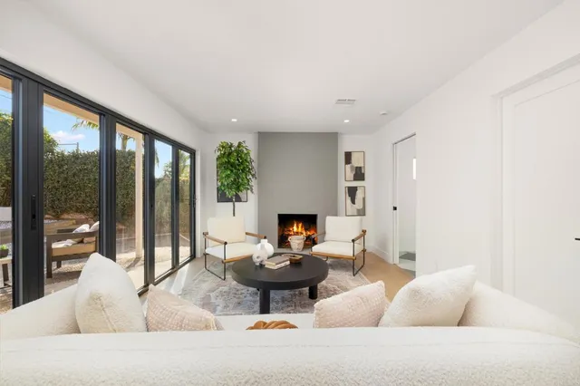 a living room with fireplace furniture and a large window
