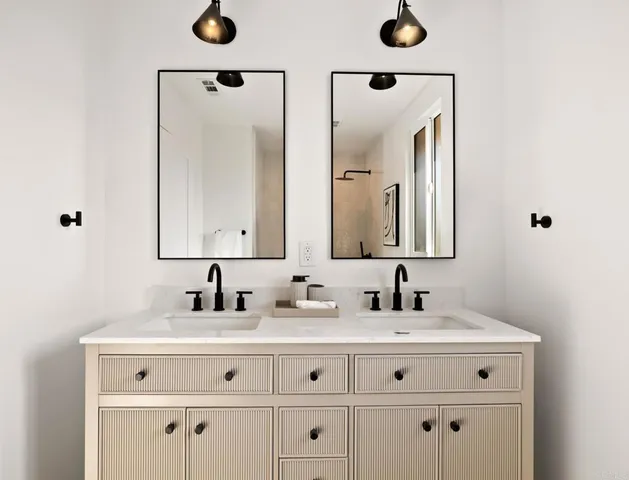 a bathroom with double vanity sinks and a mirror