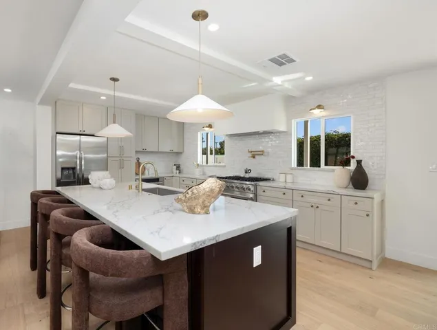 a kitchen with a stove a sink a dining table and chairs