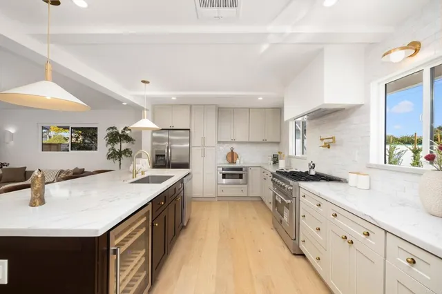 a large kitchen with stainless steel appliances lots of counter space and wooden floor