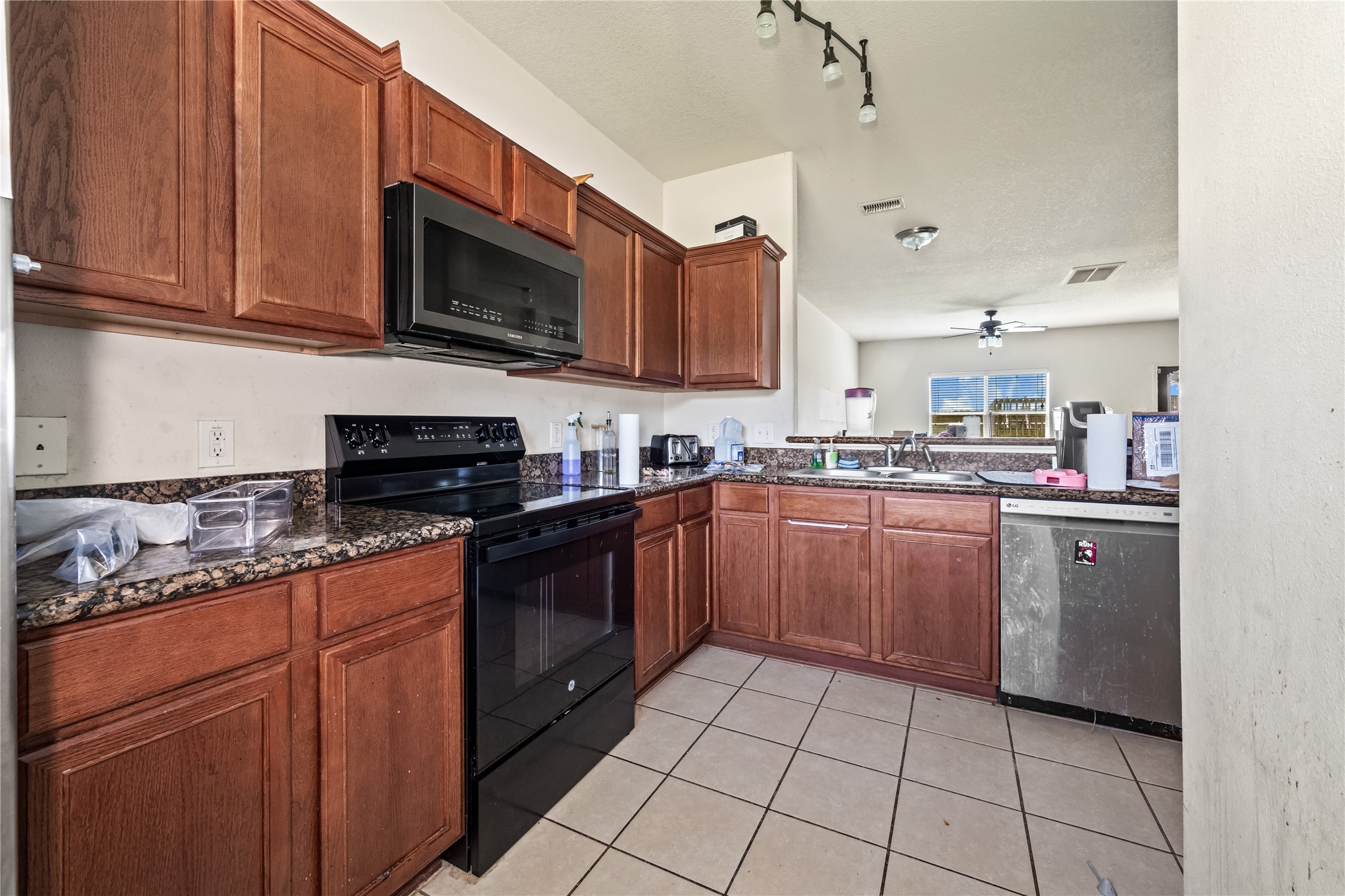 28832 San Bernard River Loop Spring, TX 77386 - Photo 15 of 50 a kitchen with stainless steel appliances granite countertop a stove top oven a sink dishwasher and a microwave oven on the blue kitchen countertops