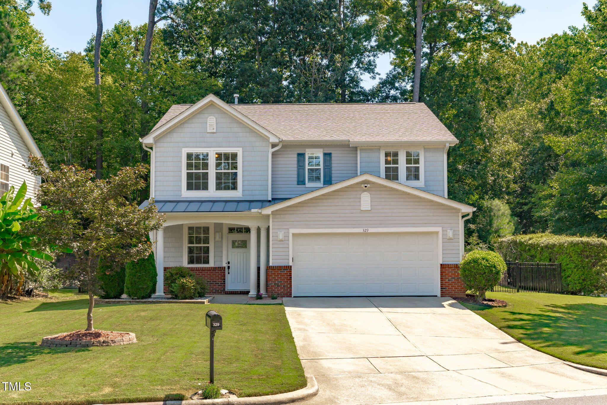 a front view of a house with a yard and trees