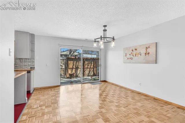 a view of a kitchen with granite countertop a refrigerator and microwave
