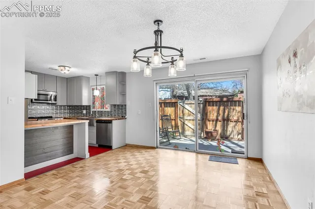 a view of a kitchen with wooden floor and a ceiling fan