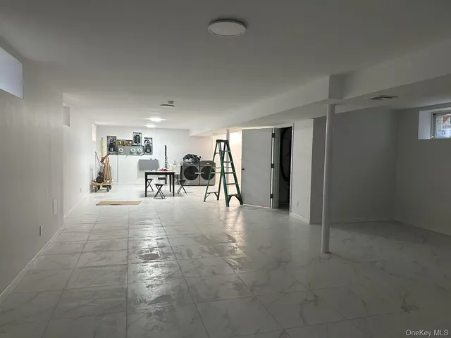 a view of a livingroom with furniture and a refrigerator