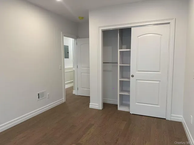 an empty room with closet and wooden floor