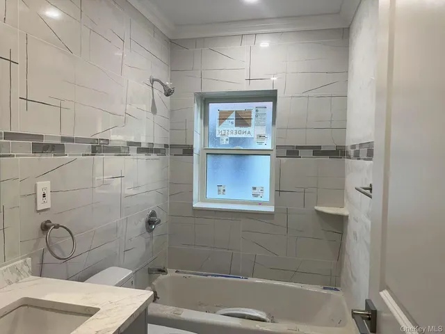 a bathroom with a granite countertop bathtub shower sink and toilet