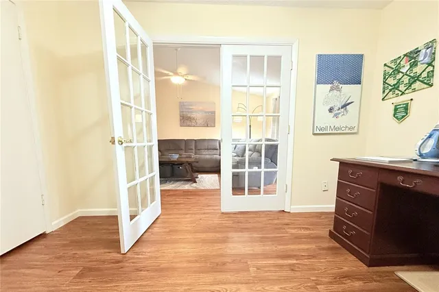 a view of a bedroom with wooden floor and windows