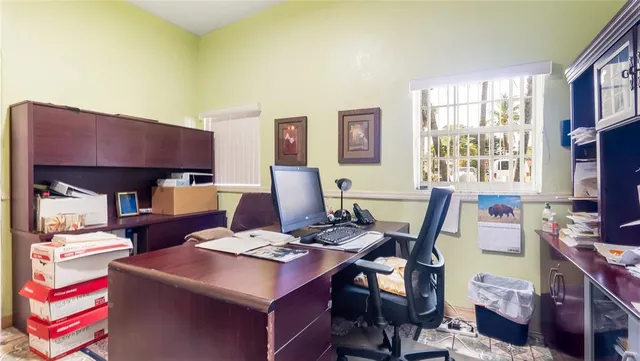 a view of a workspace with furniture and a window