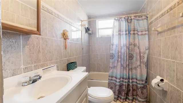a bathroom with a sink a toilet and shower curtain