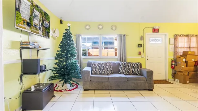 a living room with patio furniture and a potted plant