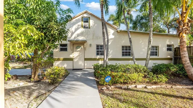 a front view of a house with a yard and potted plants
