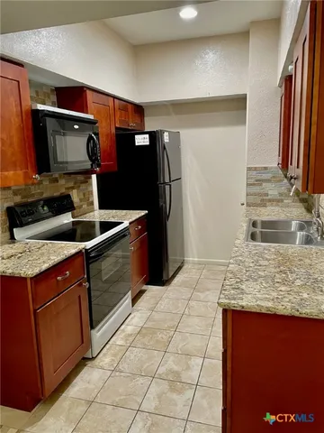 a kitchen with stainless steel appliances granite countertop a sink and a microwave