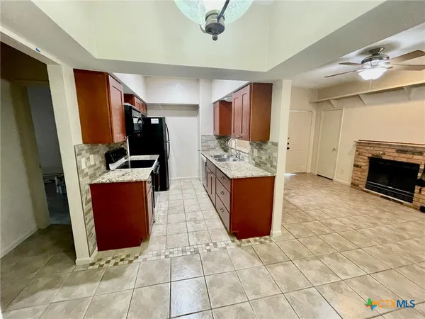 a kitchen with stainless steel appliances granite countertop a stove refrigerator and a sink