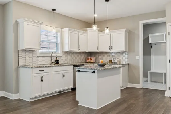 a kitchen with stainless steel appliances granite countertop a sink stove and white cabinets