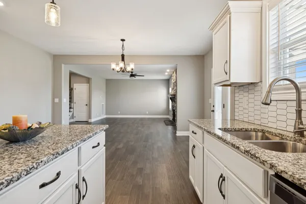 a kitchen with granite countertop a sink stainless steel appliances and cabinets