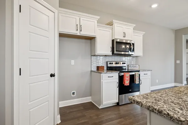 a kitchen with stainless steel appliances granite countertop a refrigerator and a stove top oven