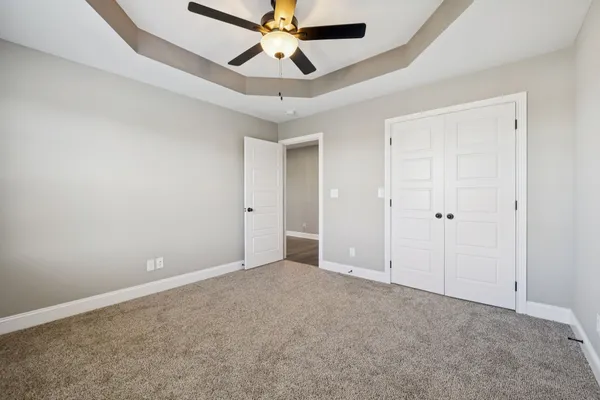 an empty room with a window and a ceiling fan