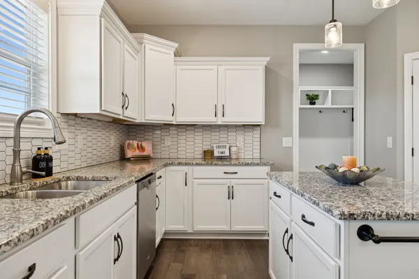 a kitchen with granite countertop a sink stove and cabinets