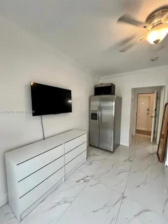 a living room with a flat screen tv and a refrigerator