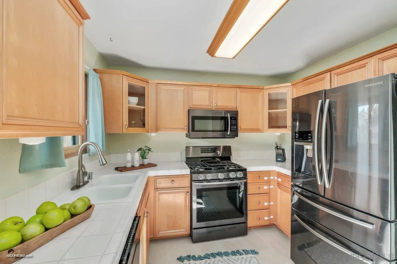 2648 Alpine Boulevard, Unit B Alpine, CA 91901 - Photo 7 of 25 a kitchen with stainless steel appliances a sink a stove a microwave a refrigerator a counter space and cabinets