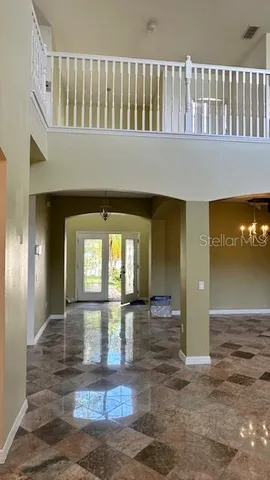 a view of a hallway with wooden floor and a living room