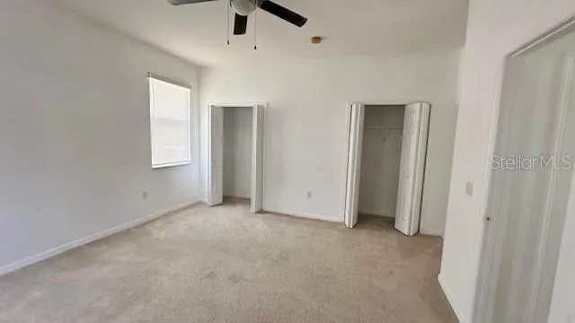 an empty room with fan and windows