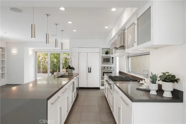 a large kitchen with kitchen island granite countertop a large window and a sink