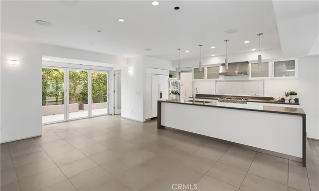 a large kitchen with stainless steel appliances a large counter top a stove and a sink