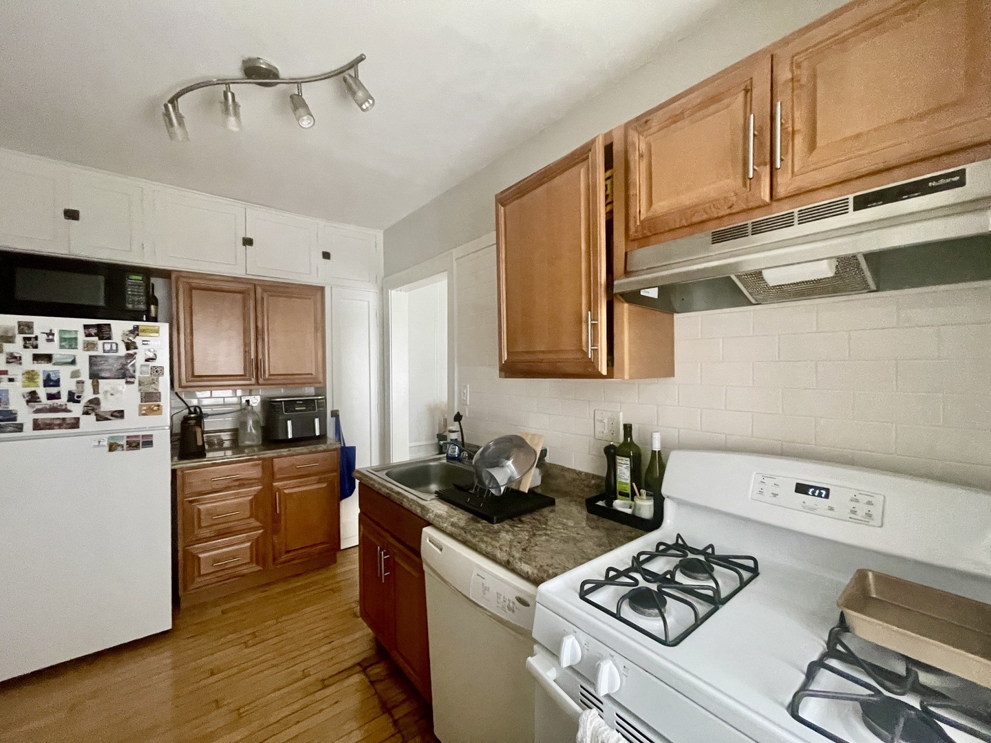 1112 Grove Street, Unit 1B Evanston, IL 60201 - Photo 5 of 14 a kitchen with stainless steel appliances granite countertop a sink stove and refrigerator