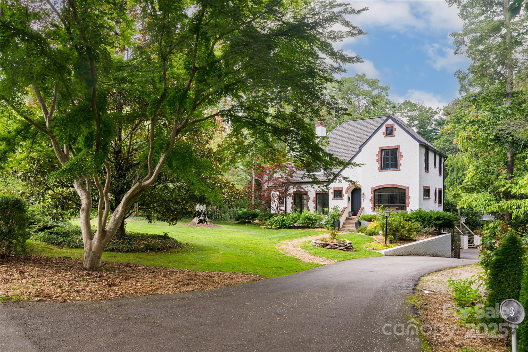 3 Lone Pine Road Biltmore Forest, NC 28803 - Photo 2 of 47 a front view of a house with a garden and trees