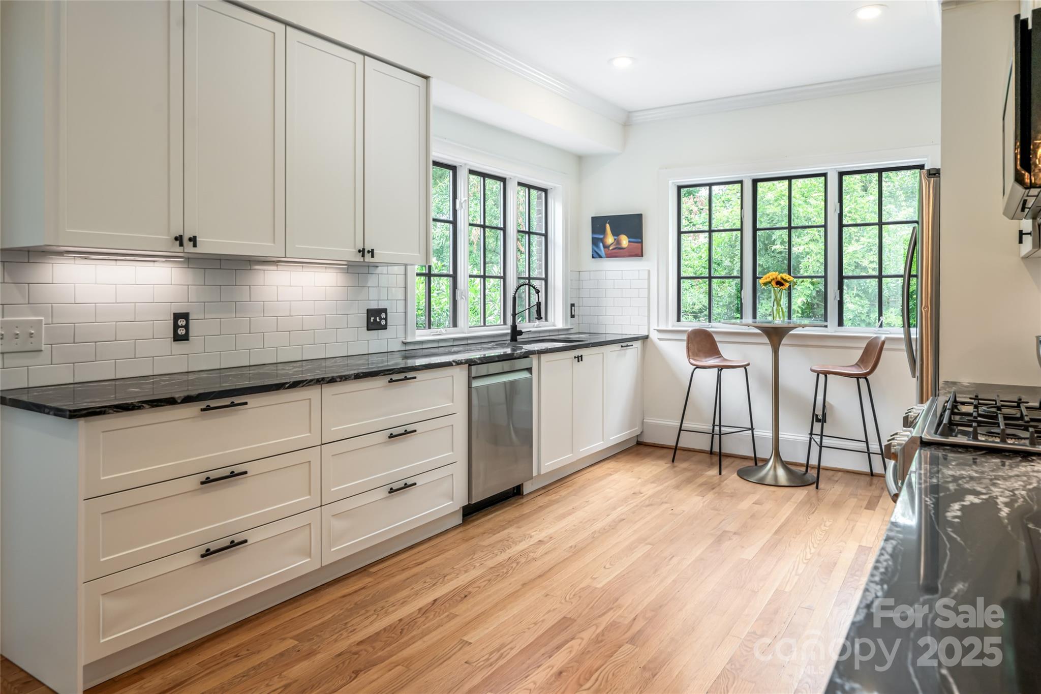 3 Lone Pine Road Biltmore Forest, NC 28803 - Photo 9 of 47 a kitchen with granite countertop a stove a sink and white cabinets with wooden floor