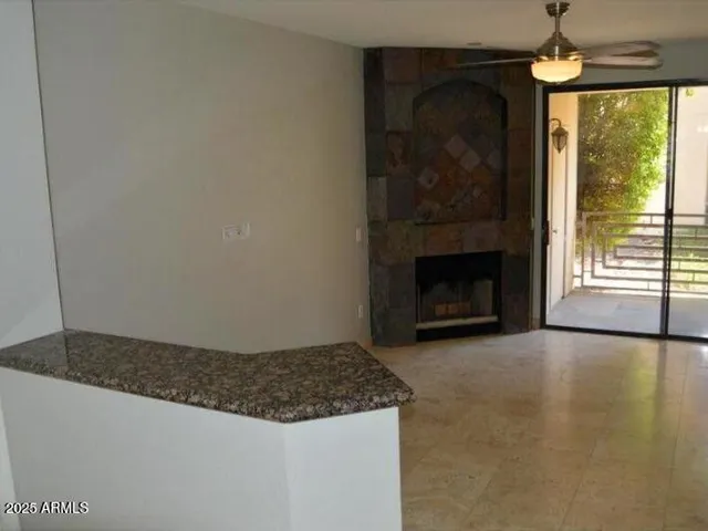 a living room with fireplace and a large window