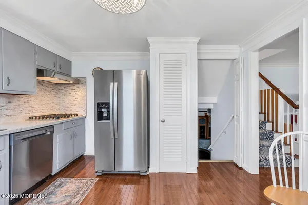 a kitchen with stainless steel appliances granite countertop a refrigerator and a stove top oven