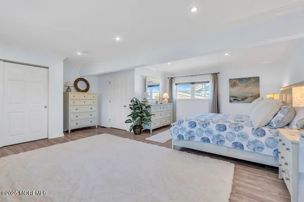 a spacious bedroom with a bed and a potted plant