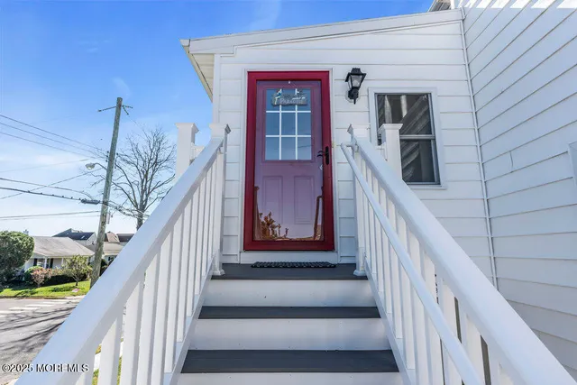 a view of staircase with railing and white walls