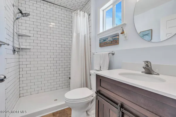 a bathroom with a granite countertop sink a toilet and a mirror