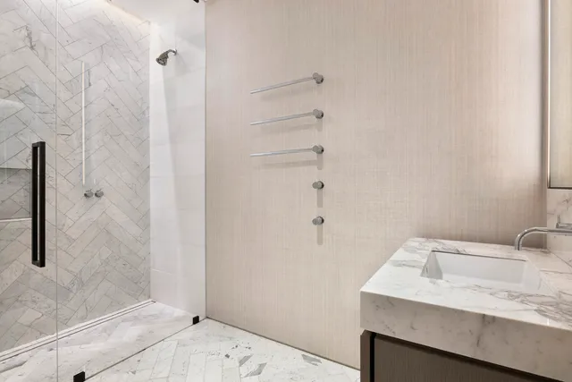 a bathroom with a granite countertop sink and shower